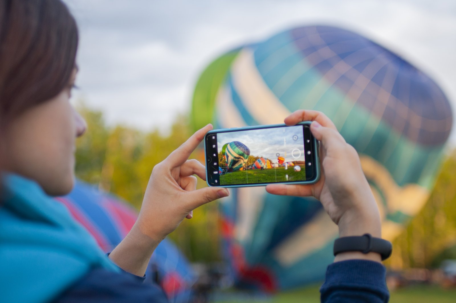 woman photographs hot air balloons with mobile pho 2026 09 22 21 37 40 utc